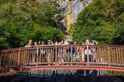 ‘비와야폭포·하장성마을 투어’ 참가자들이 폭포 절벽을 배경으로 기념사진을 찍고 있다.  