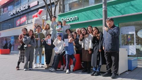 사진: 행사에 참여한 부모와 아이들이 신촌 리본 매장 앞에서 기념사진을 촬영하고 있다 